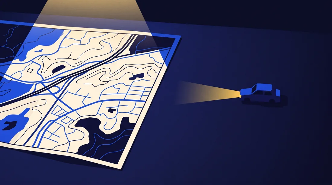 A lit paper map ending in a hard edge, with a small car sitting out in the dark blank area beyond it.